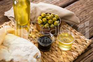 Marinated olives and oil bottle on wooden table