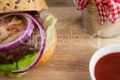 Hamburger and tomato sauce on chopping board