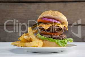 Hamburger and french fries in plate on wooden table