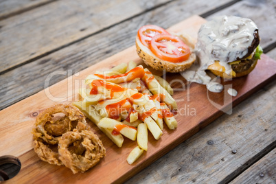 French fries with sauce by burger and onion rings