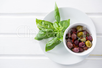 Marinated olives with green leaves in plate