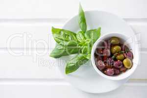 Marinated olives with green leaves in plate