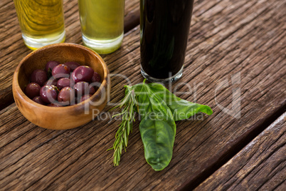 Marinated olives with olive oil and balsamic vinegar bottles on table