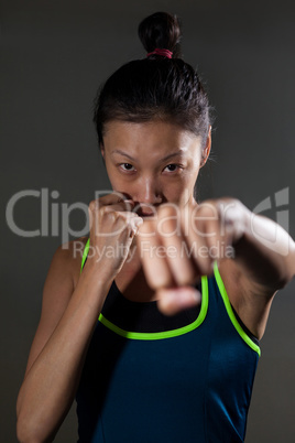 Determined woman practicing boxing in fitness studio