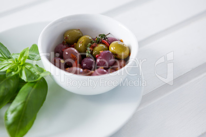 Marinated olives with green leaves in plate