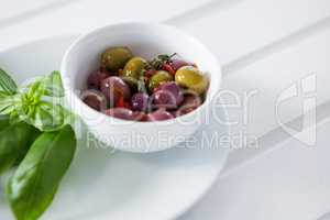 Marinated olives with green leaves in plate