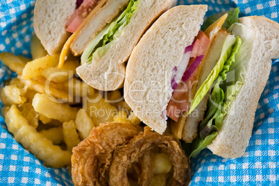 Close up of sliced burger with French fries and onion rings