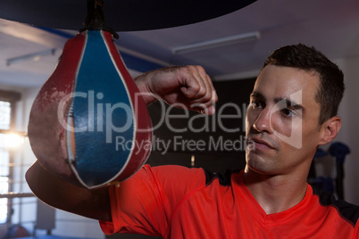 Male boxer practicing boxing with punching bag