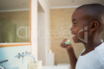 Side view of smiling boy with toothbrush