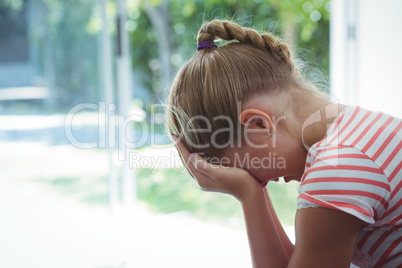 Side view of girl with head in hands