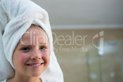 Portrait of smiling girl with hair wrapped in towel