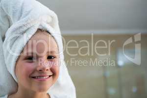 Portrait of smiling girl with hair wrapped in towel