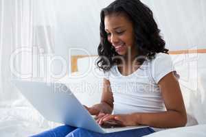 Smiling girl using laptop at home