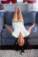 High angle view of girl lying on sofa