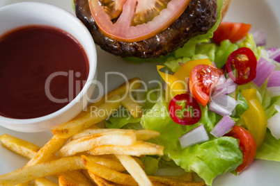 Overhead view of salad with burger and french fries