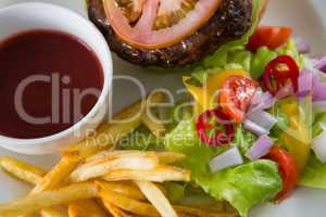 Overhead view of salad with burger and french fries