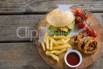 Overhead view of burger and fries with onion rings by sauce