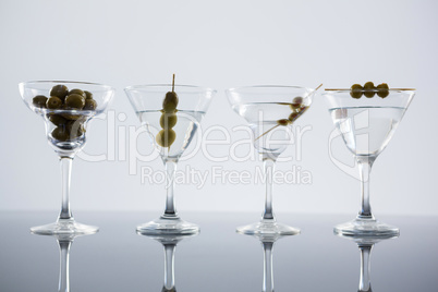 Cocktail martini with olives on table