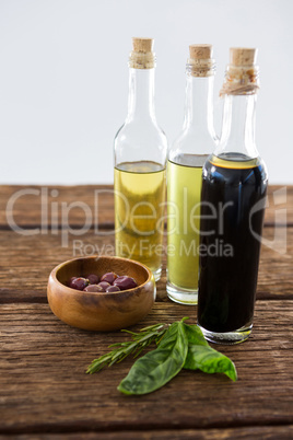 Marinated olives with olive oil and balsamic vinegar bottles on table