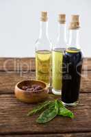 Marinated olives with olive oil and balsamic vinegar bottles on table