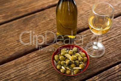 Close-up of marinated olives with glass of wine