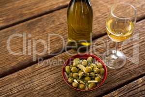 Close-up of marinated olives with glass of wine