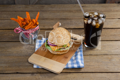 Hamburger, french fries and cold drink on table