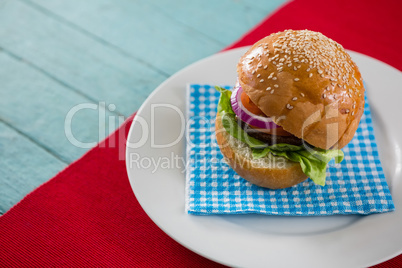High angle view of hamburger served on napkin in plate