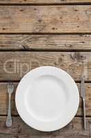 Overhead view of empty plate amidst fork and table knife