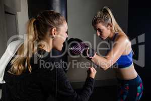 Trainer cheering woman while practicing boxing
