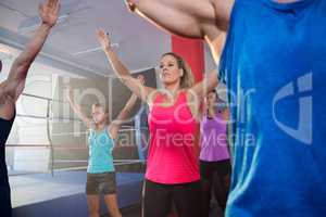 Athletes exercising with arms raised by boxing ring