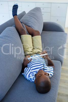 High angle view of boy using digital tablet on sofa at home
