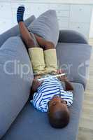 High angle view of boy using digital tablet on sofa at home