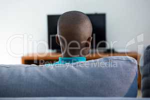 Rear view of boy sitting on sofa at home