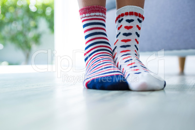 Low section of girl wearing different socks