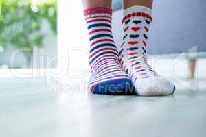 Low section of girl wearing different socks