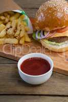 Hamburger, french fries and tomato sauce on table