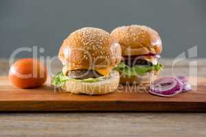 Close up of cheeseburgers with onion and tomato