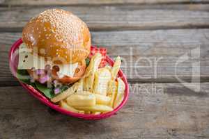 Cheeseburger and French fries in red basket