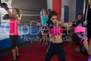 Young female boxers practicing boxing by ring