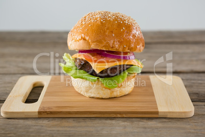 Close up of hamburger with cheese on cutting board
