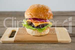 Close up of hamburger with cheese on cutting board