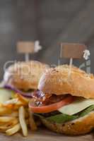 Hamburger with tag and french fries on wooden table