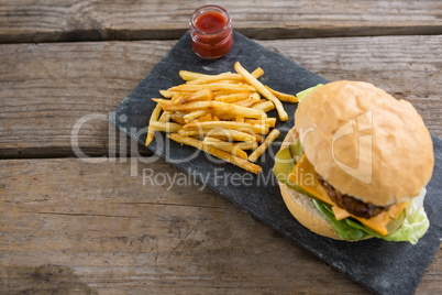 High angle view of cheeseburger with french fries and sauce