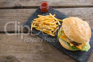 High angle view of cheeseburger with french fries and sauce