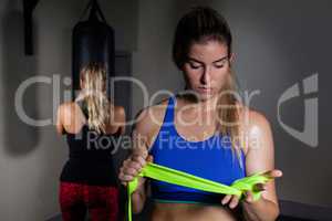 Woman tying hand wrap on hand in fitness studio
