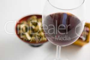 Close-up of marinated olives with glass of wine