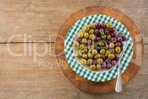 Marinated olives with herbs on wooden board