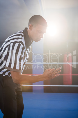 Young male referee gesturing in boxing ring