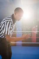 Young male referee gesturing in boxing ring